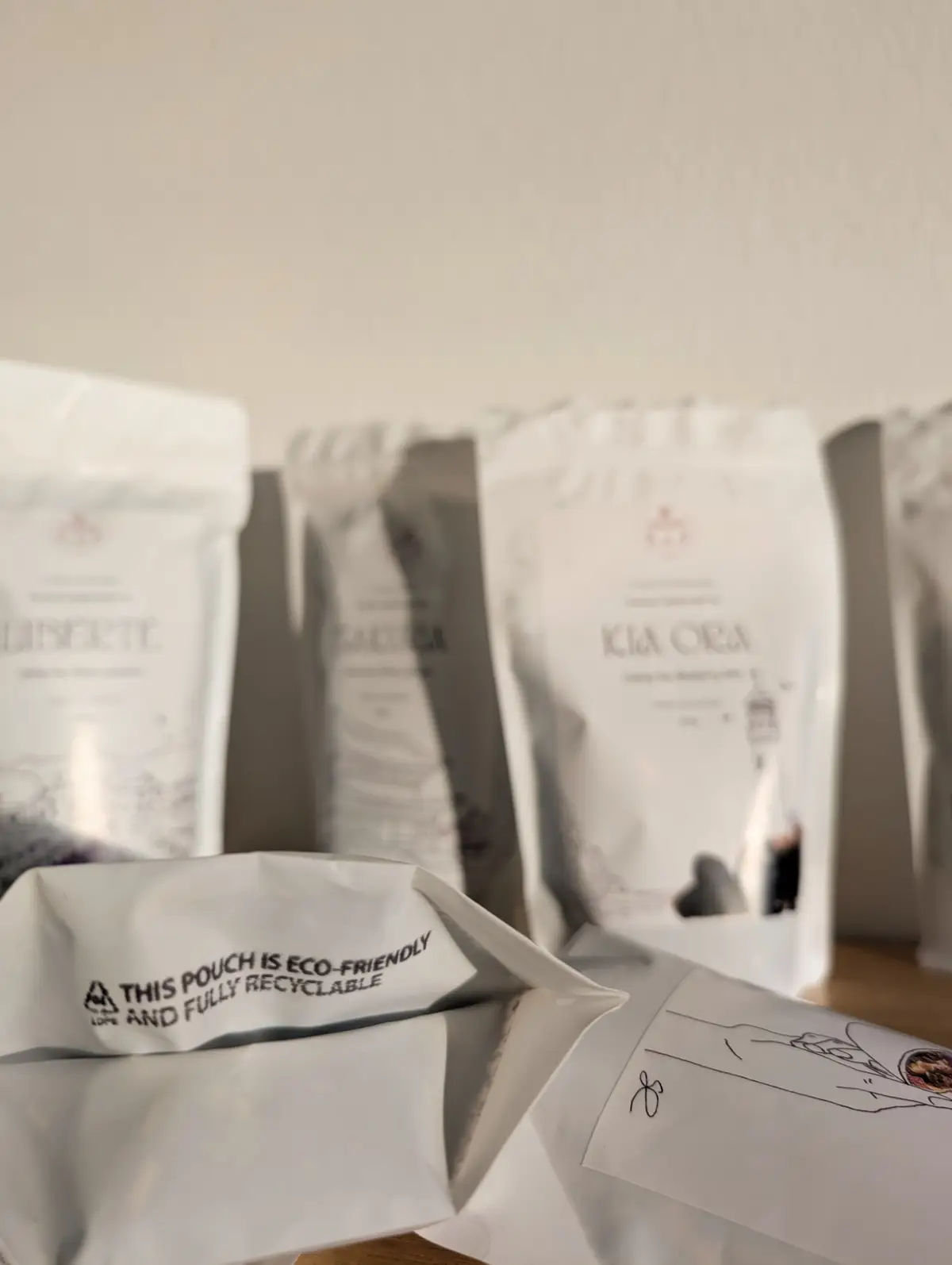 Weiße, recycelbare Erinora Doypack-Teebeutel auf einem Tisch angeordnet