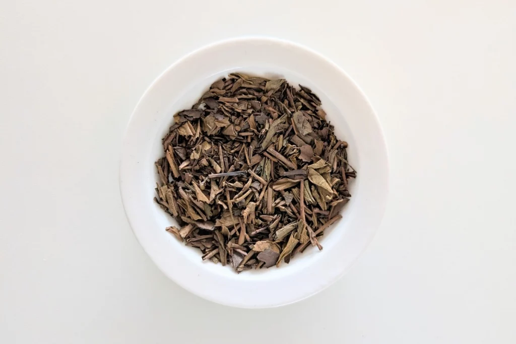 Foglie di Hojicha tostate in una ciotola bianca, tè giapponese a basso contenuto di caffeina
