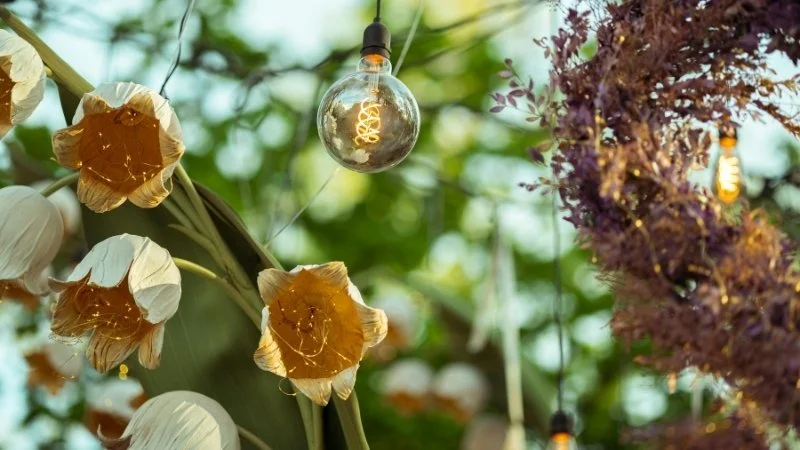 Decorazioni floreali e luci calde per l'atmosfera di una cerimonia all'aperto