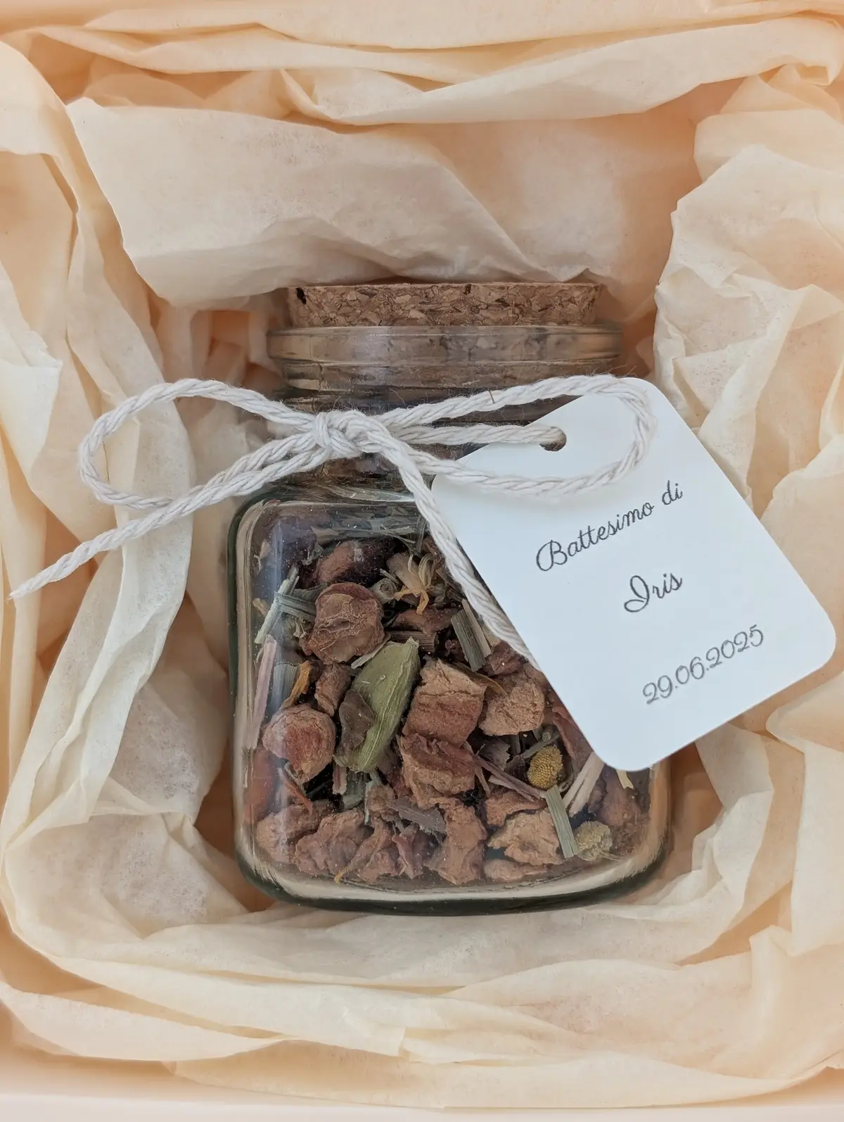 Glass jar wedding favour with loose leaf tea, custom tag, and ribbon, presented in a gift box with tissue paper